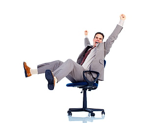 man raising both hand and feet while sitting on black swivel chair